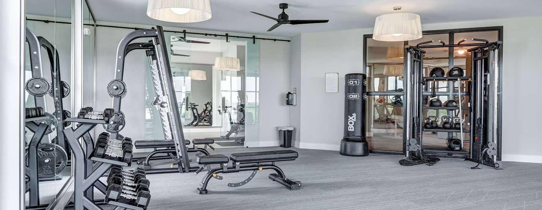 weights and mirrors in bright fitness center